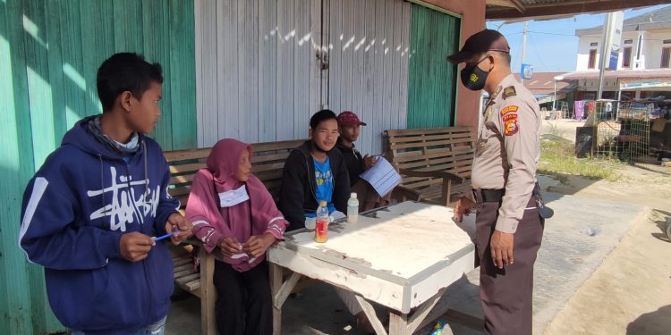 Polisi Kecamatan Langgam Pelalawan Pantau Kepatuhan Prokes Masyarakat Desa Segati