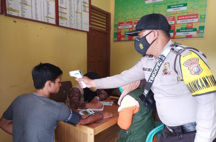 Bhabinkamtibmas Polsek Kerumutan Terus Kawal Vaksinasi di Desa Binaannya