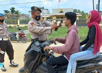 Polisi Bagikan Masker Gratis di Depan Mapolsek Teluk Meranti Pelalawan