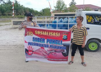 Bentangkan Spanduk, Polsubsektor Pelalawan Sosialisasikan Saber Pungli Kepada Pengguna Jalan