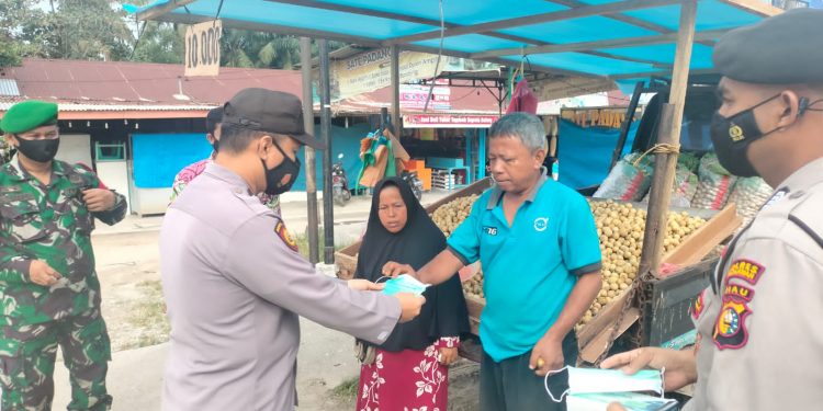 Tekan Penyebaran Covid-19, Polsek Pangkalan Kerinci Bagikan Masker Kepada Masyarakat