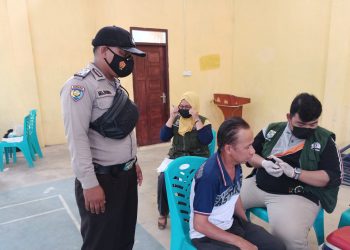 Personel Polsek Kerumutan dan Babinsa Kawal Vaksinasi di Desa Binaan