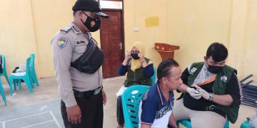 Personel Polsek Kerumutan dan Babinsa Kawal Vaksinasi di Desa Binaan