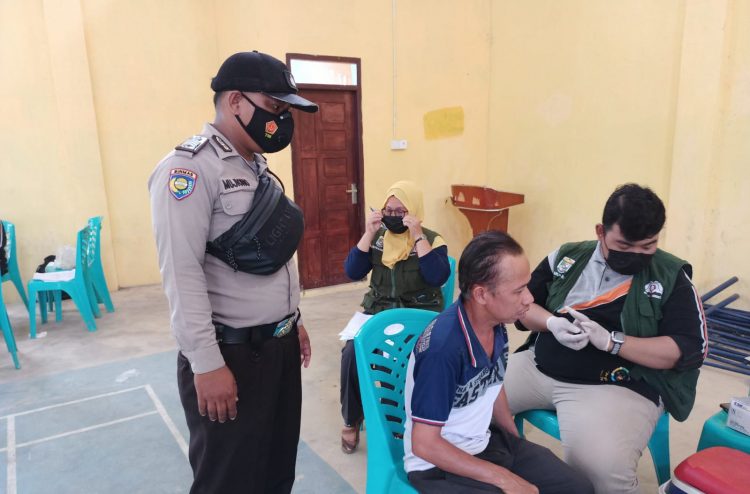 Personel Polsek Kerumutan dan Babinsa Kawal Vaksinasi di Desa Binaan