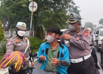 Polisi Bersama Masyarakat Ditlantas Polda Riau Bagikan Masker